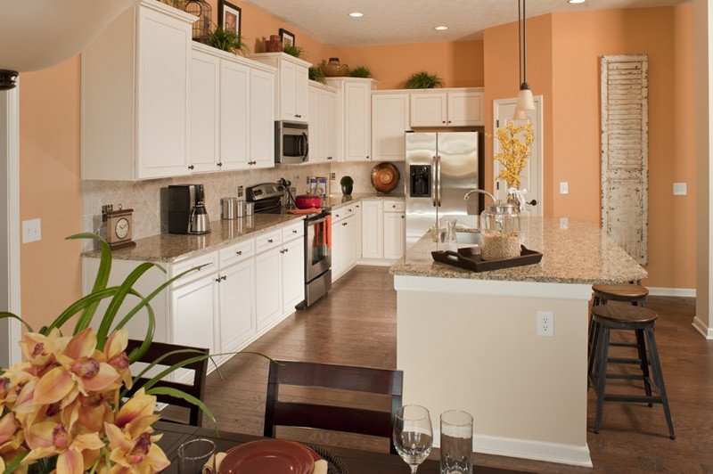 Белая мебель в кухне со стенами персикового цвета