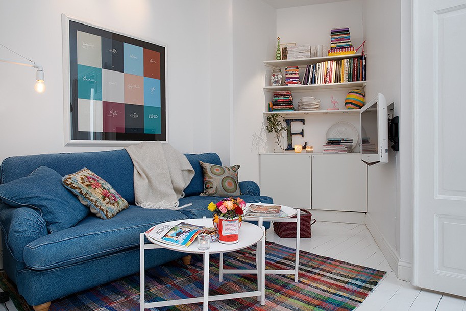 Синий диван в небольшой гостиной скандинавского стиля