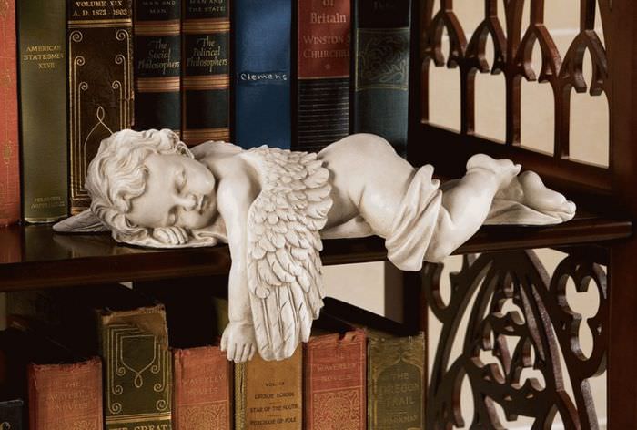 Фигурка ангела на полке с книгами